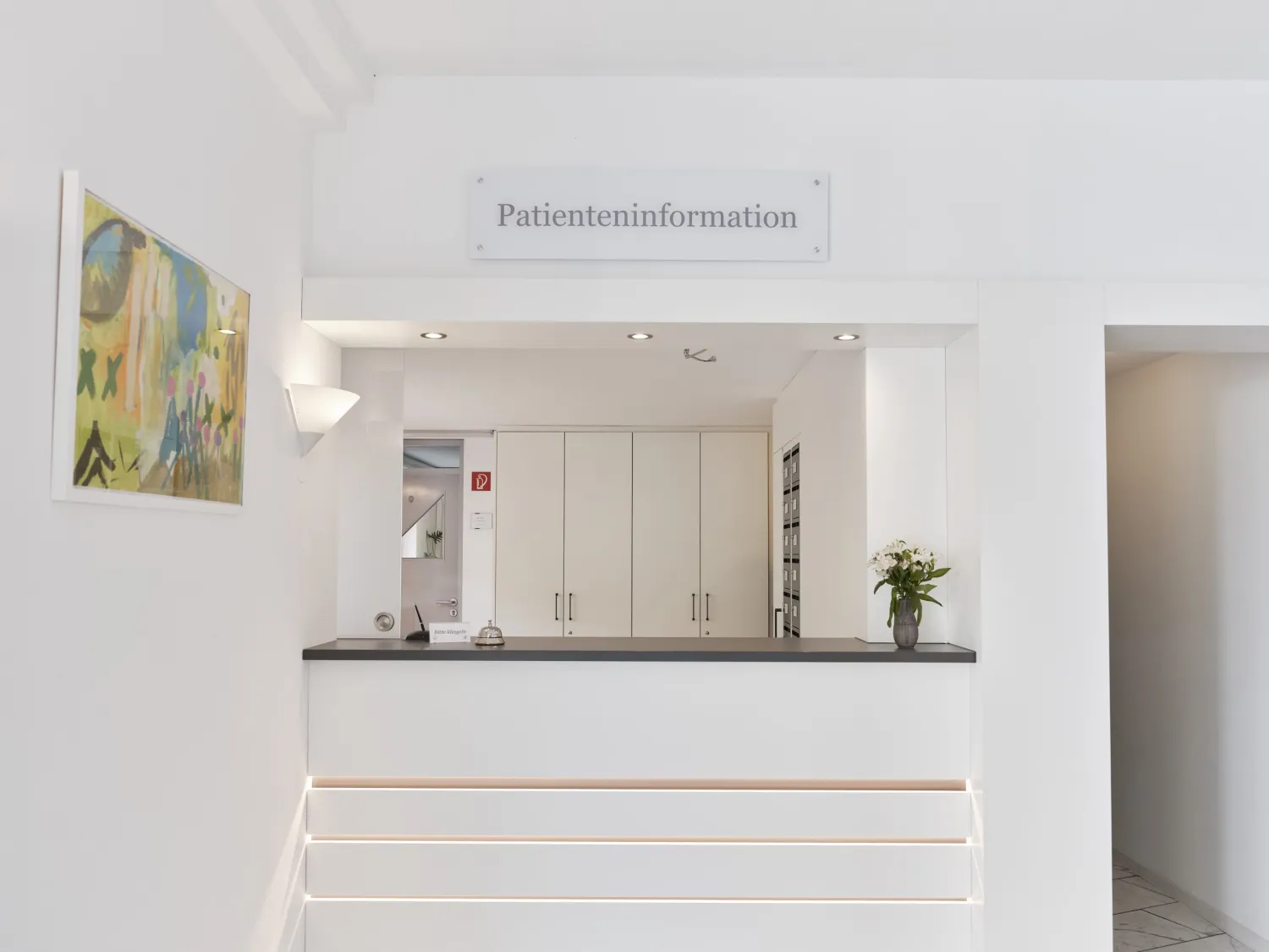Heller Empfangstresen mit Schild „Patienteninformation