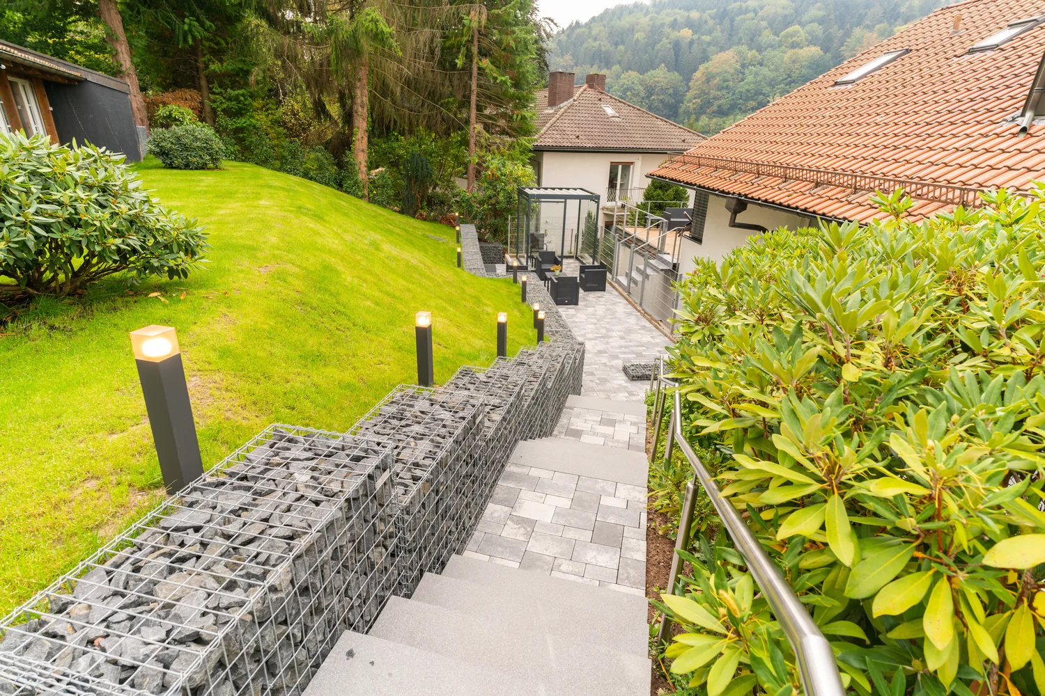 Gepflasterter Gartenweg mit Natursteinmauer zur Klinik