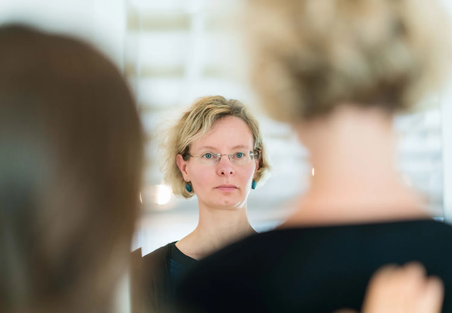Nahaufnahme einer Frau im Gespräch über die Schulter einer zweiten Person