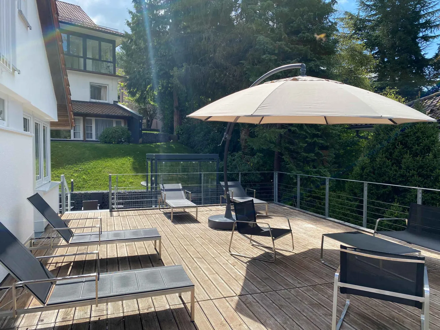 Terrasse mit großem Sonnenschirm und Liegen